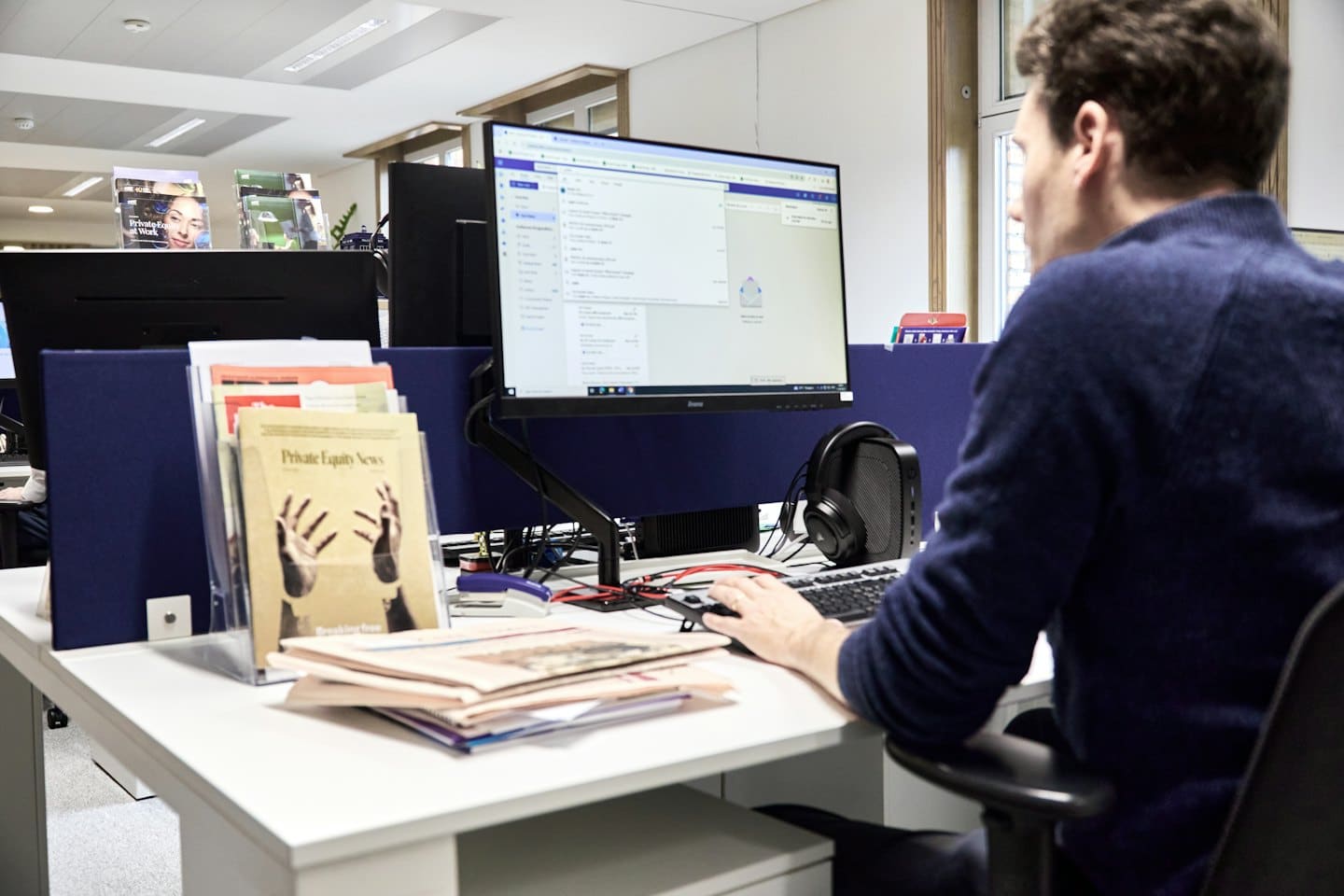 Uomo che lavora al computer in un ufficio moderno.